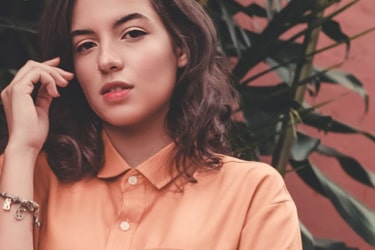 A young woman in a peach-colored shirt